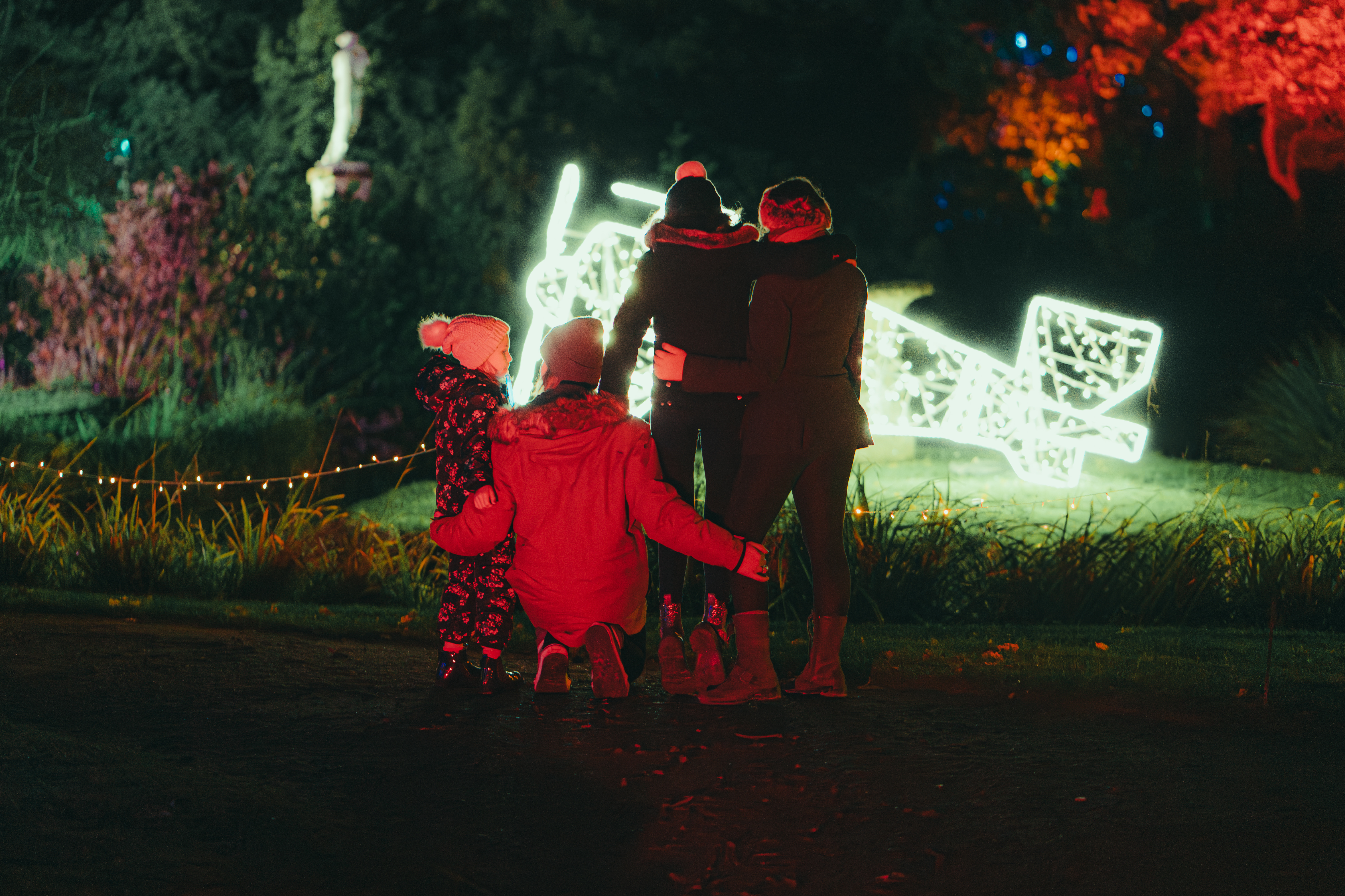 Family Stood In Front Of The Aircraft Lights In Swiss Garden. Shuttleworth In Lights 2025. © The Shuttleworth Trust. Photo Mach 3 Studio.